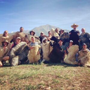 Group posing with sheepskins they tanned